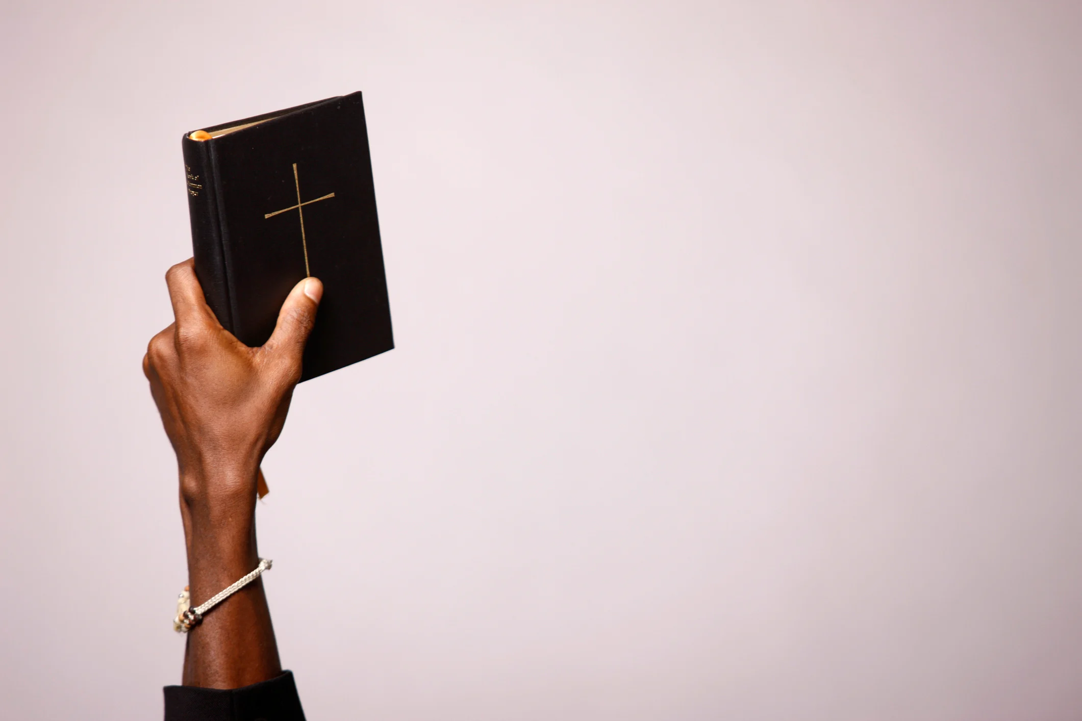 Hand holding a Bible up high